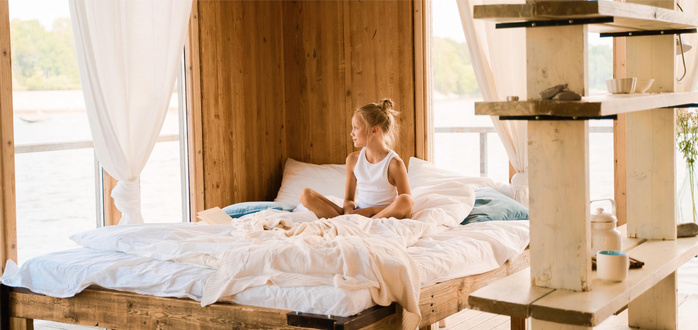 Girl Sitting on Bed Looking through Window